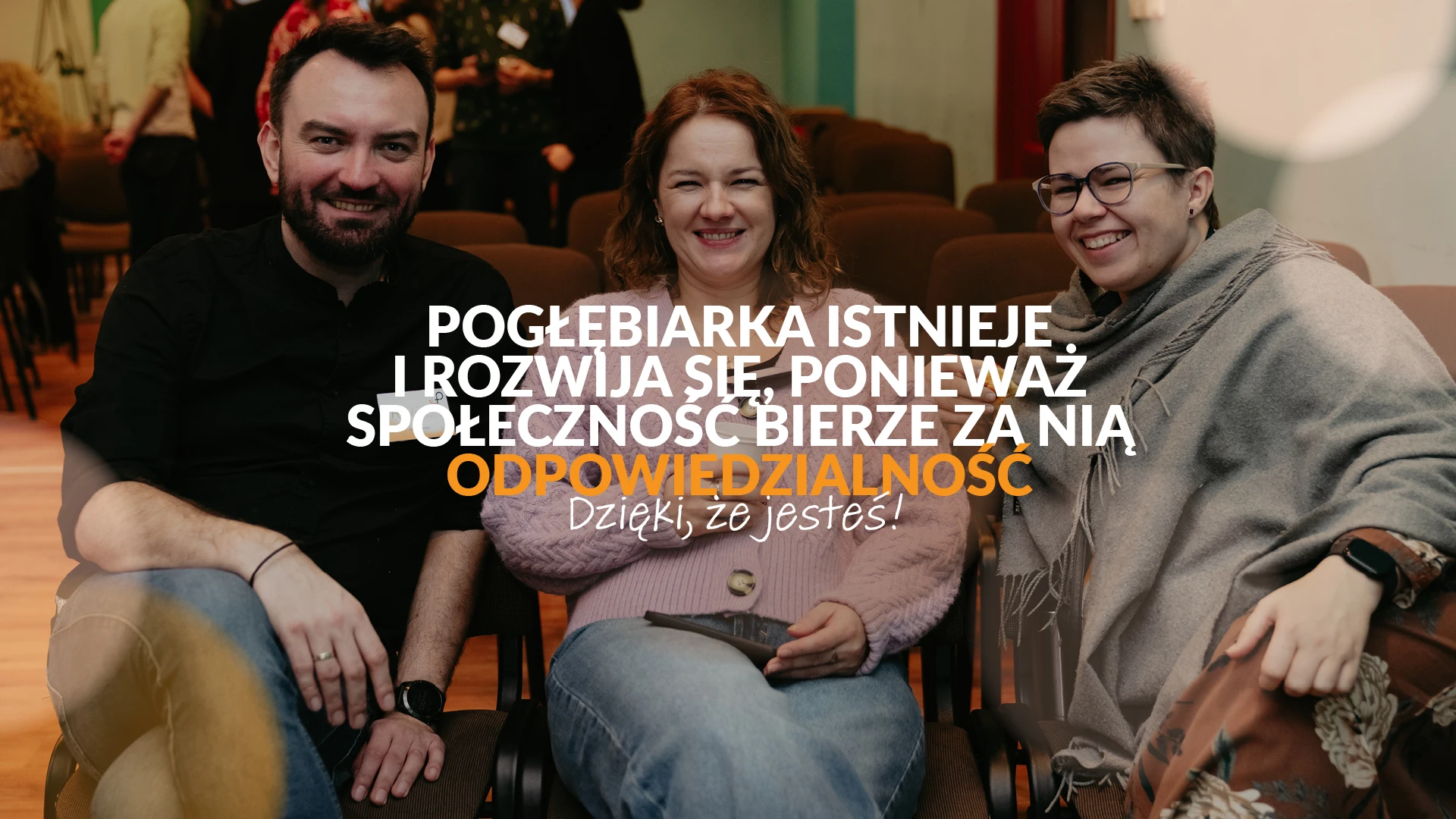 Dwie kobiety i mężczyzna na fotelach. Napis